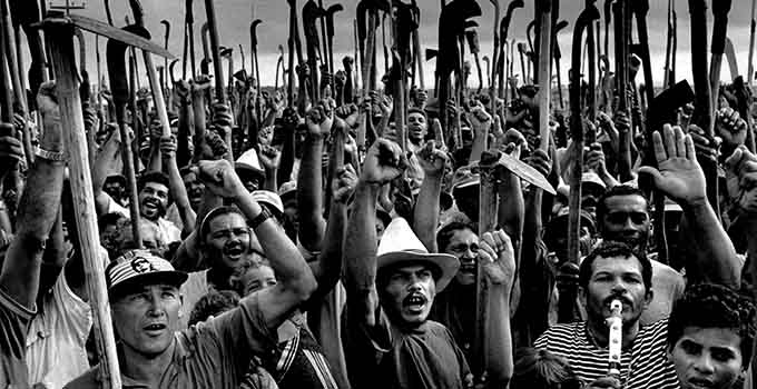 Le Movimento dos Trabalhadores Rurais Sem Terra, [Mouvement des travailleurs ruraux sans-terres] est né en 1984, mais la lutte des paysans brésiliens contre la concentration des propriétés foncières (détenues par l’Etat et les classes au pouvoir grâce au système latifundia, héritage de la colonisation portugaise) avait commencé dans les années 1950.
