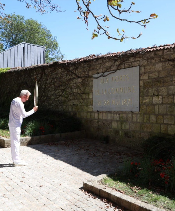 28 août 2024 - Jean-Louis Maugère l’un des porteurs de la flamme s’incline devant le Mur des Fédérés au cimetière du Père Lachaise où 150 partisans de la Commune furent fusillés.